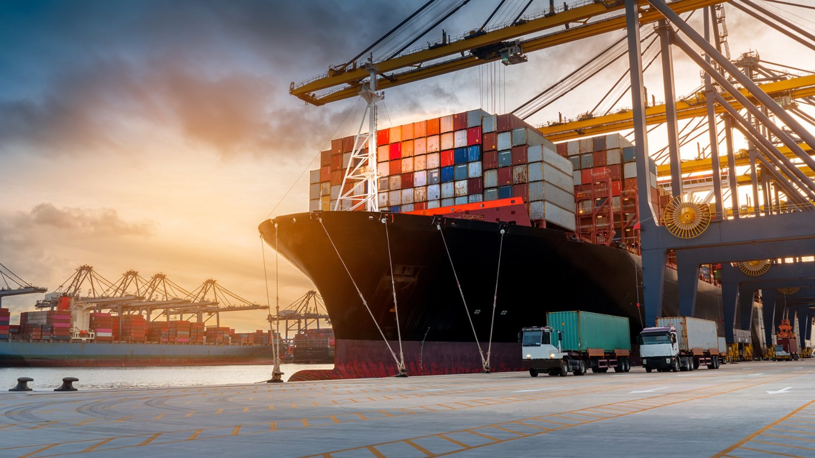 crane loading cargo container from truck to container ship in the international terminal logistic sea port concept freight shipping by ship 