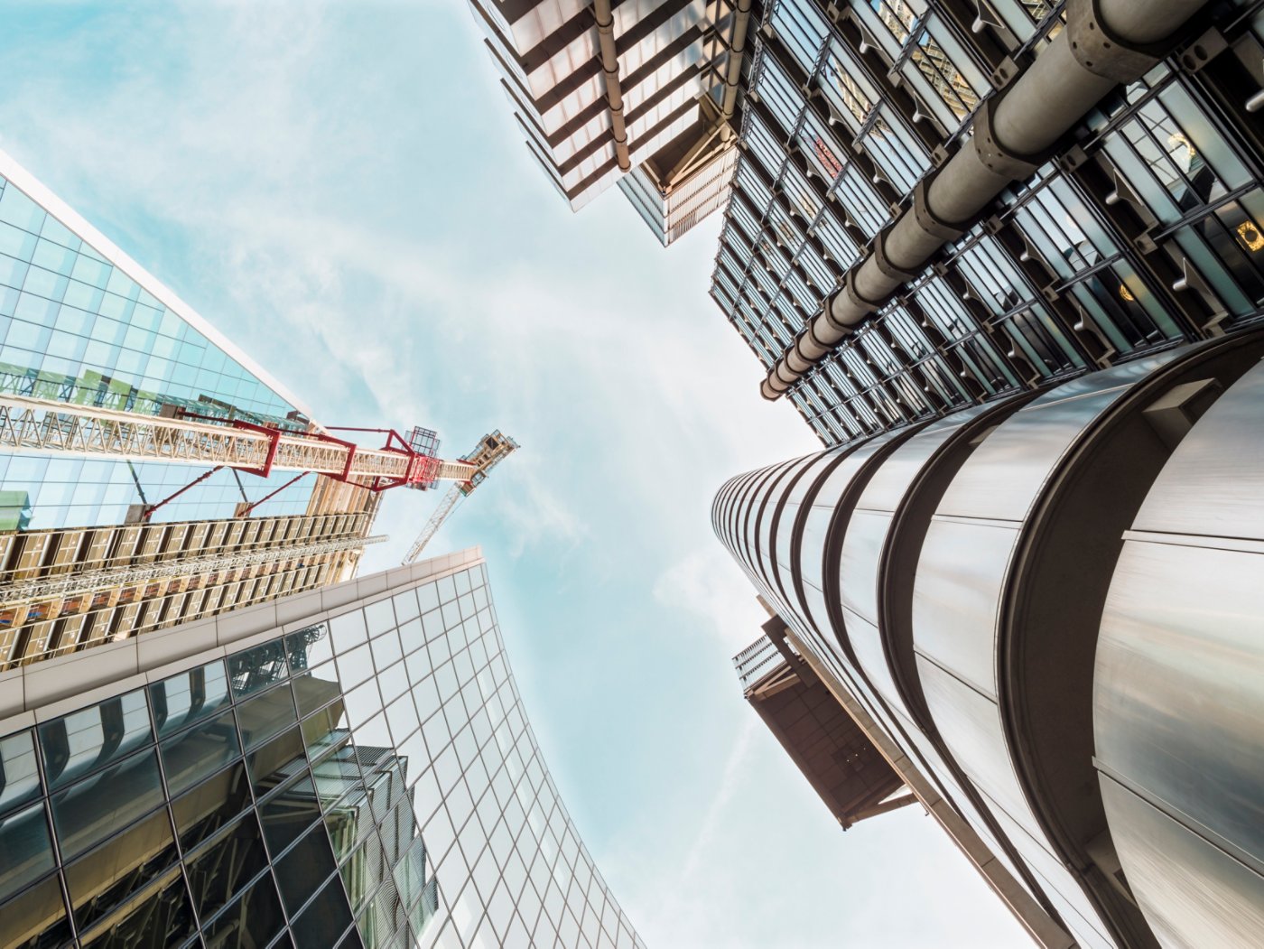 City of London skyscrapers area sky low angle view looking up view from the street with reflection on facades and architecture details of the Lloyds building, The Pinnacle and Willis Tower seen from the bottom on a beautiful sunny summer day