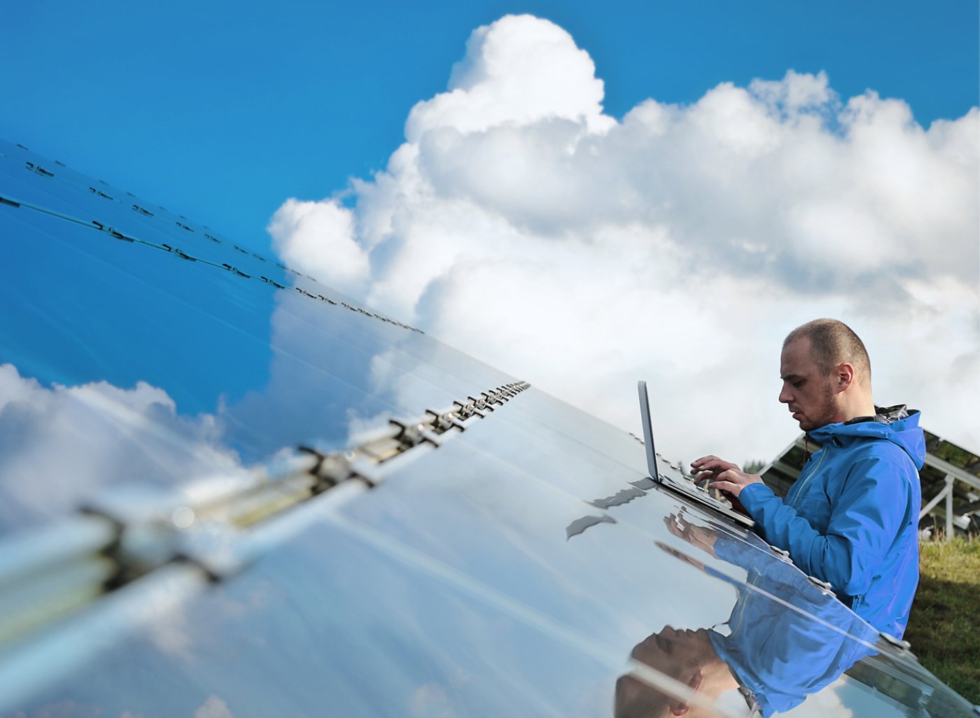 Male engineer with laptop working on solar panels