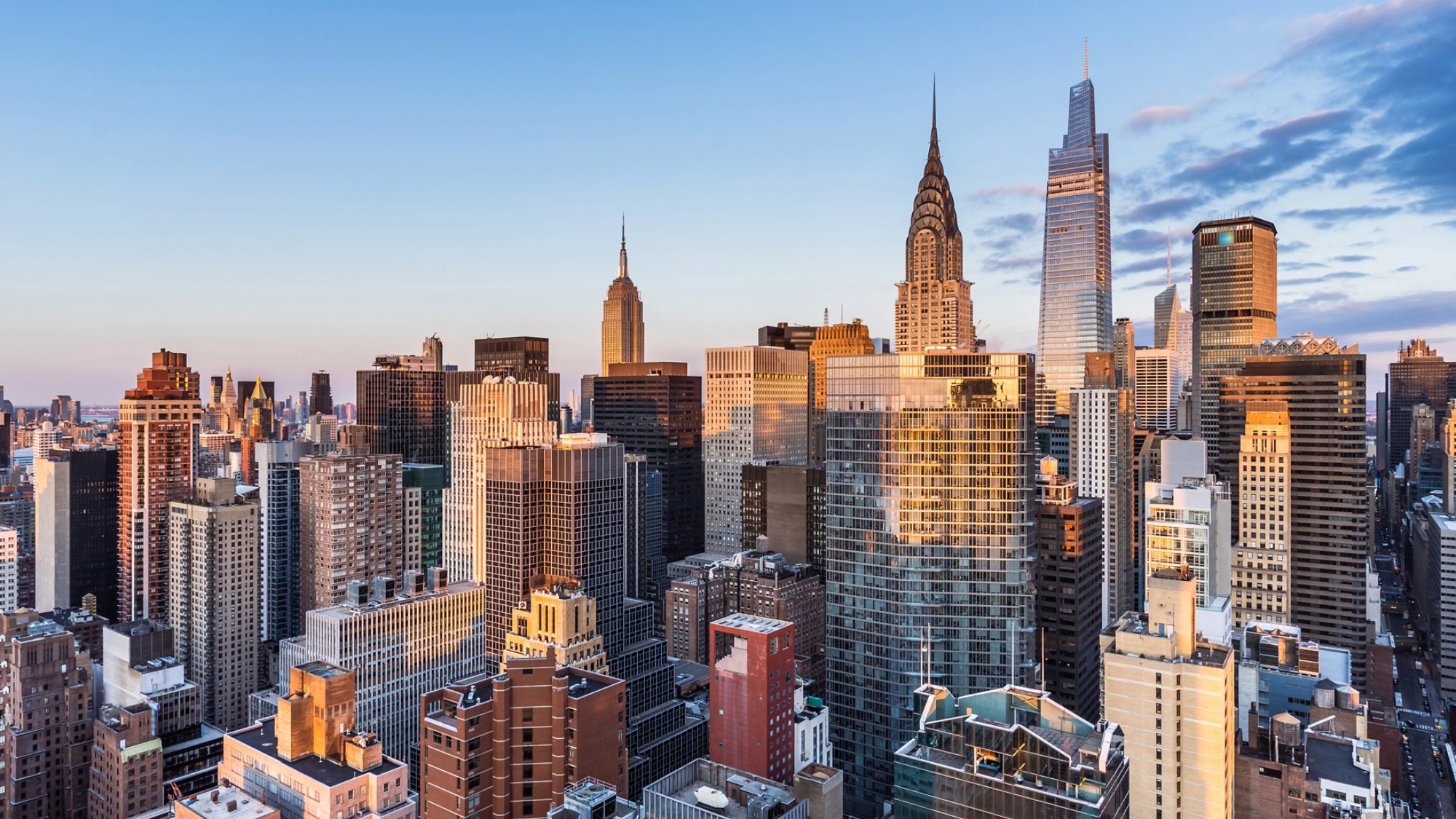 This high angle sunrise view from UN Plaza on the east side of Manhattan looks southwest over the Kips Bay neighborhood toward the Empire State Building, the Chrysler Building, and One Vanderbilt with Lower Manhattan and One World Trade Center in the distance.