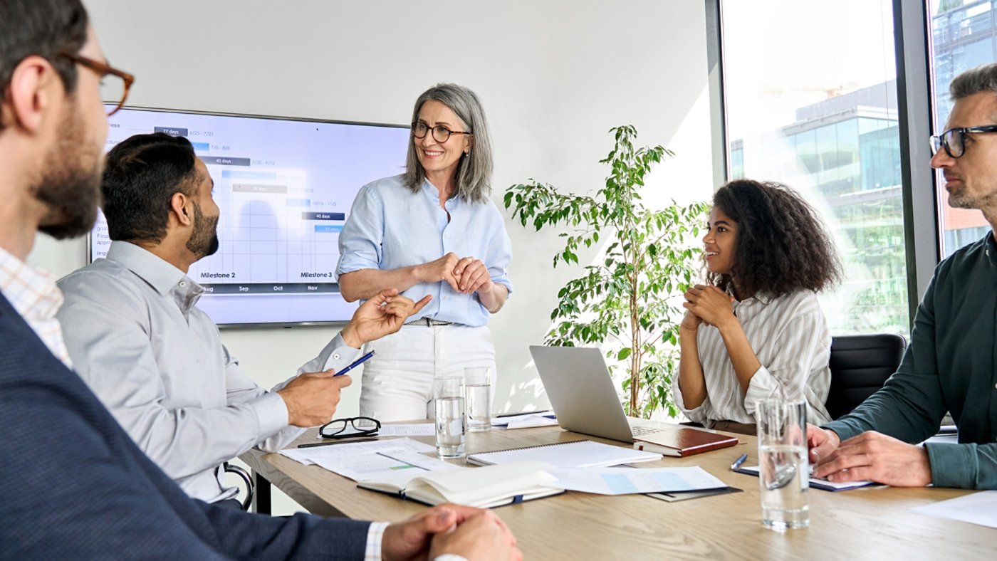 International executive team people having board meeting discussing project results. Diverse employees group working with senior leader brainstorming in office meeting room at presentation training.