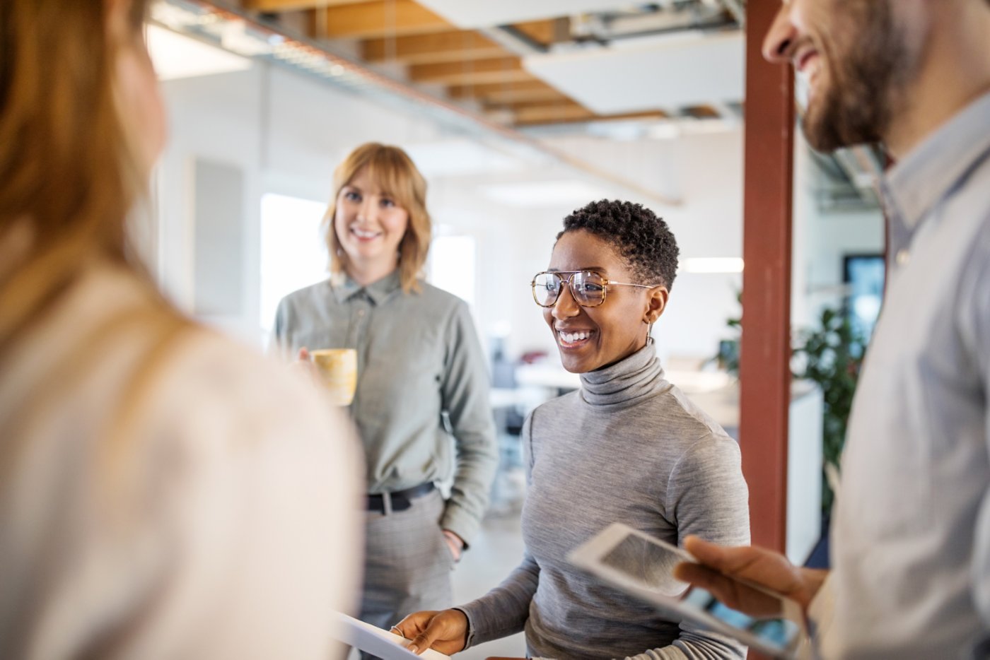 Group of multi-ethnic business team having a standing meeting in office. Business people talking during a break in office.