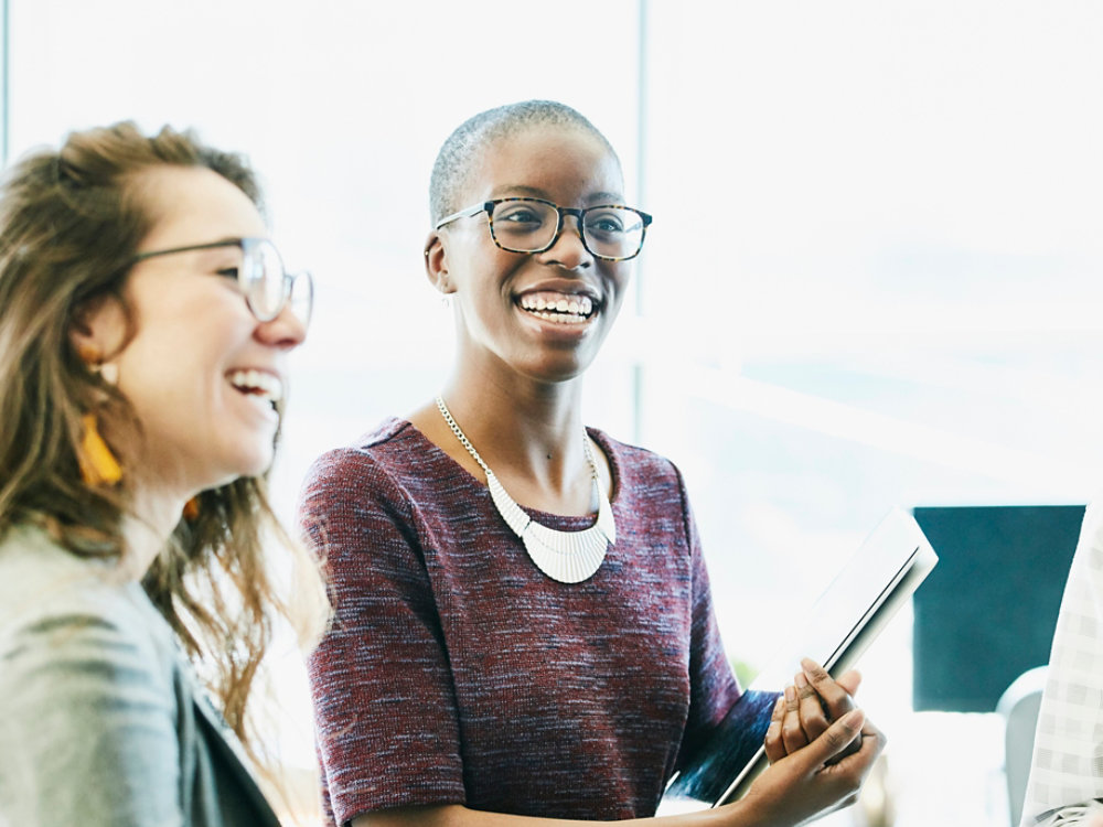 Smiling business colleagues in discussion during informal meeting in start up office