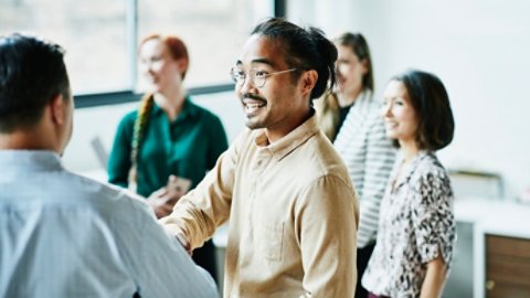 Businessman shaking hands with colleague after meeting in office