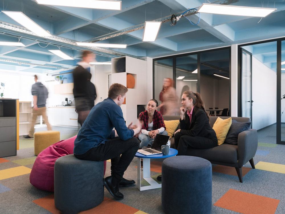 Multiethnic startup business team on meeting in a modern bright open space coworking office. Brainstorming, working on laptop. Group of coworkers walking around in motion blur. High quality photo