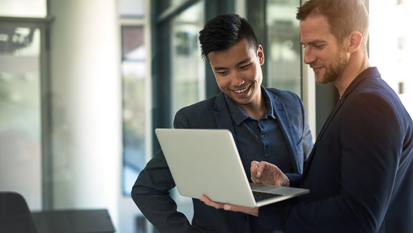 Shot of two business colleagues discussing something on a laptop in an office 16X9