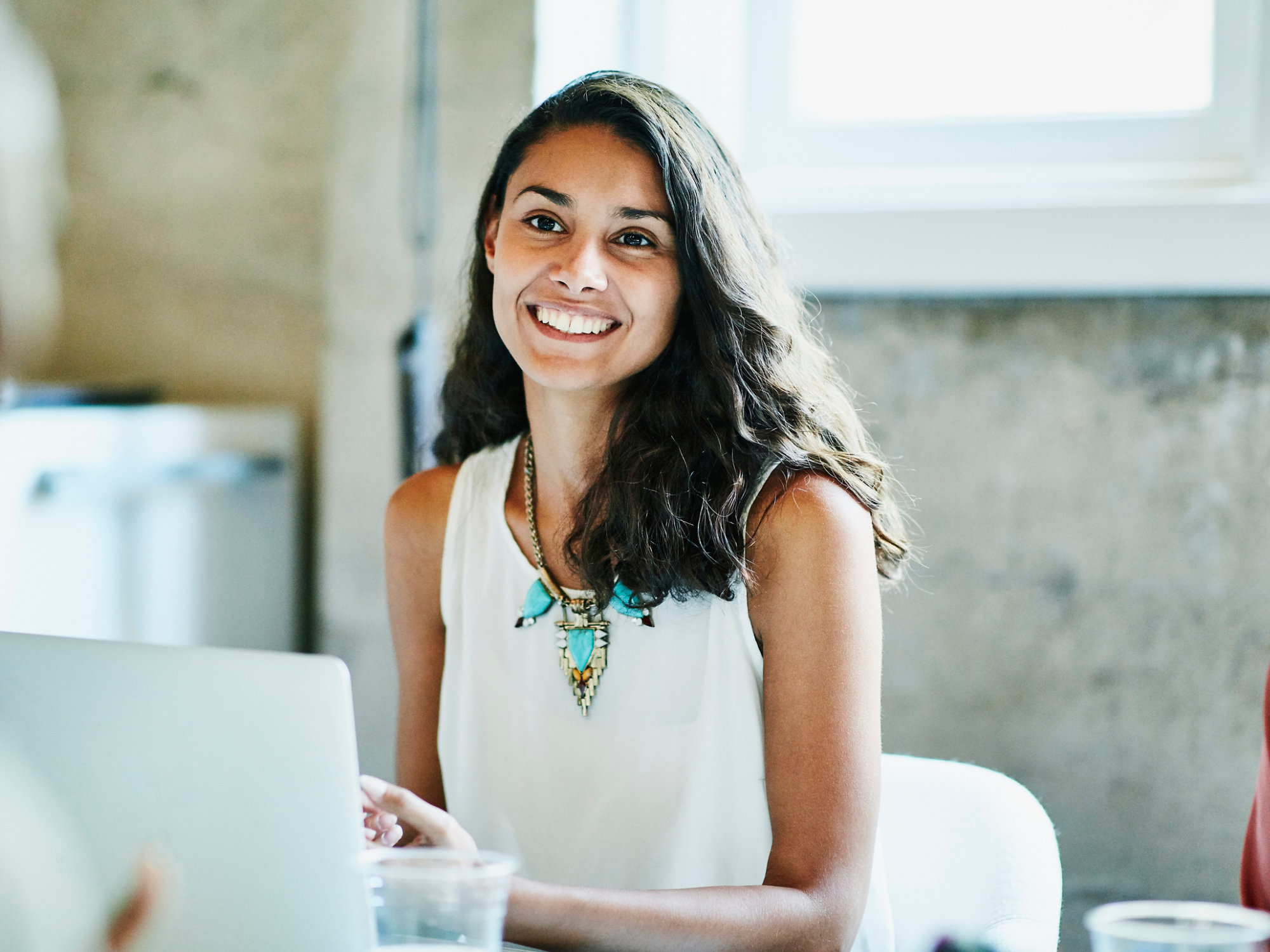 Smiling businesswoman in discussion with colleagues during meeting in office conference room