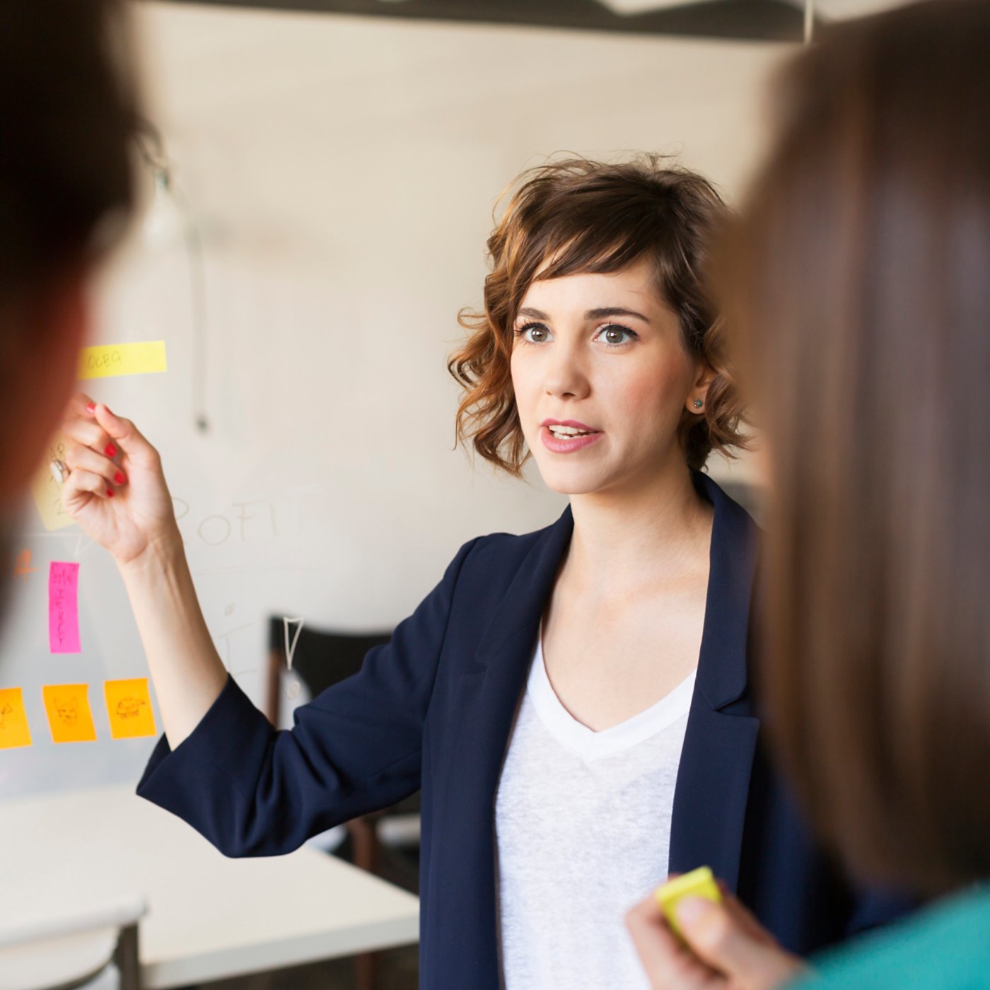 Businesswoman explaining presentation to colleagues in office