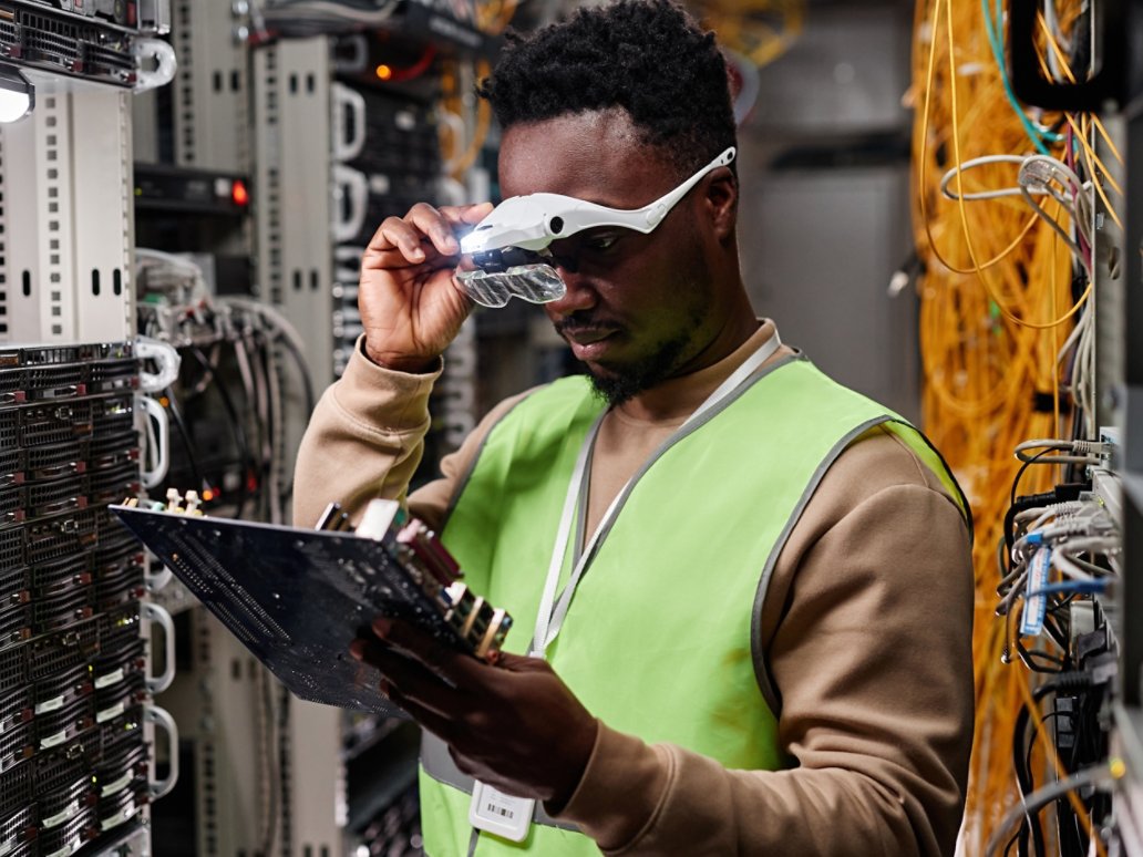 Waist up portrait of technician repairing servers in data center and inspecting computer parts