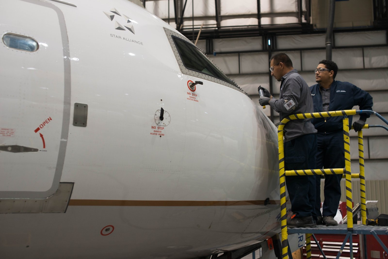 two workers in front of plane