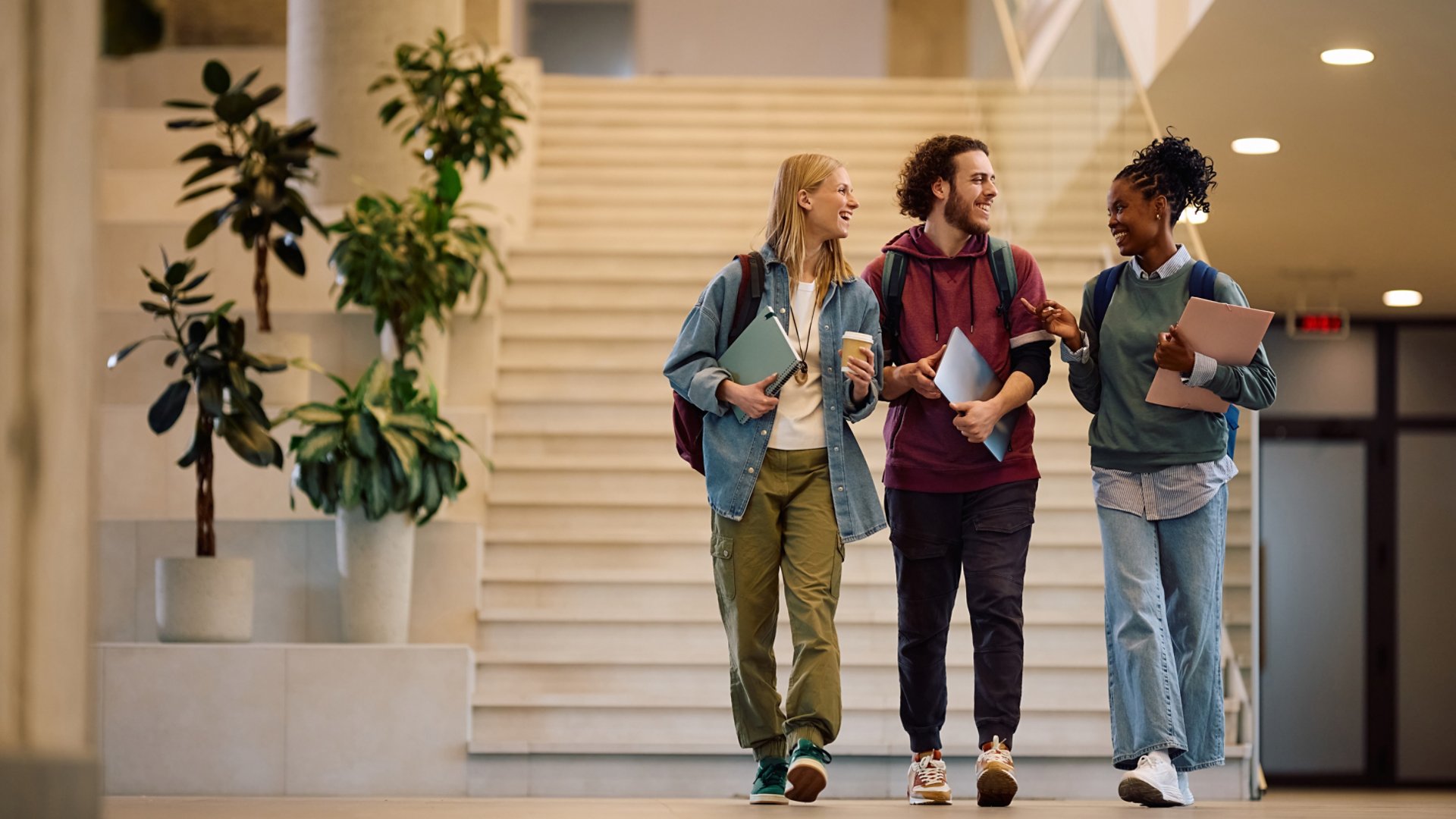 Multiracial group of happy college students communicating while  going on a lecture. Copy space.