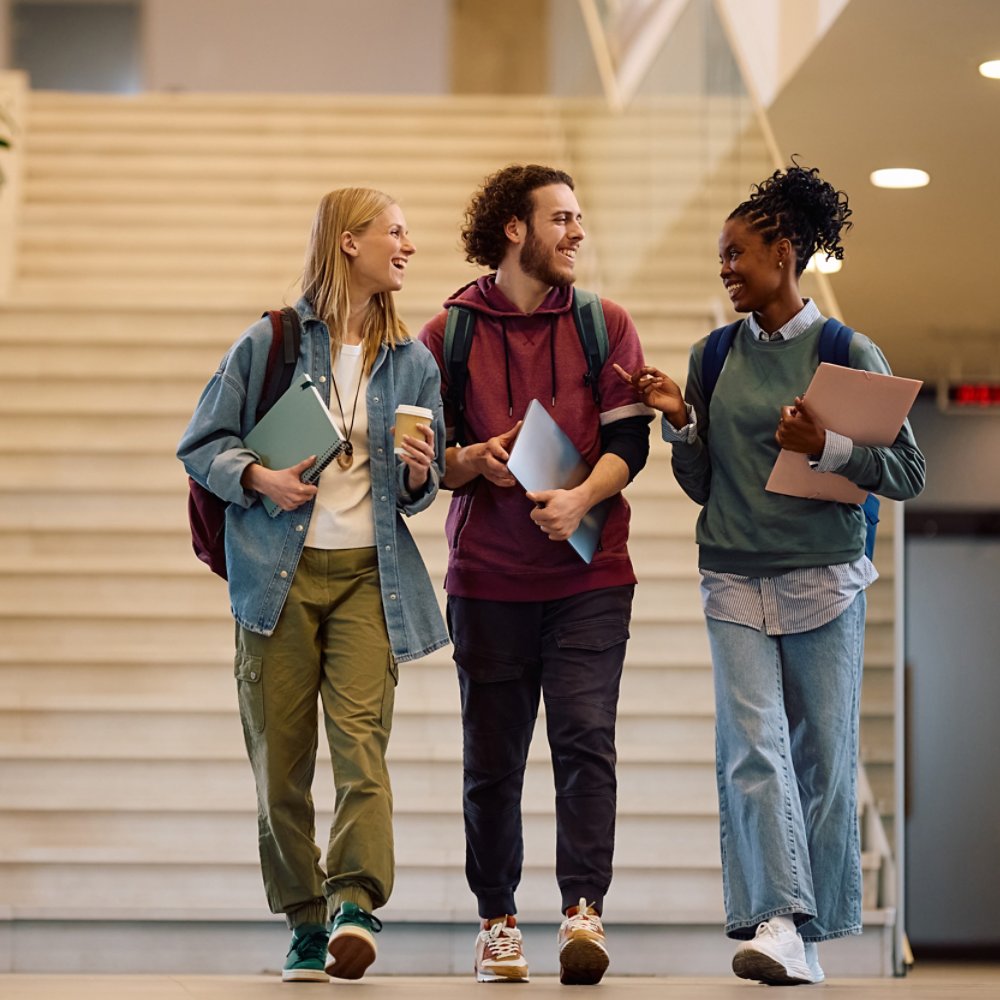 Multiracial group of happy college students communicating while  going on a lecture. Copy space.
