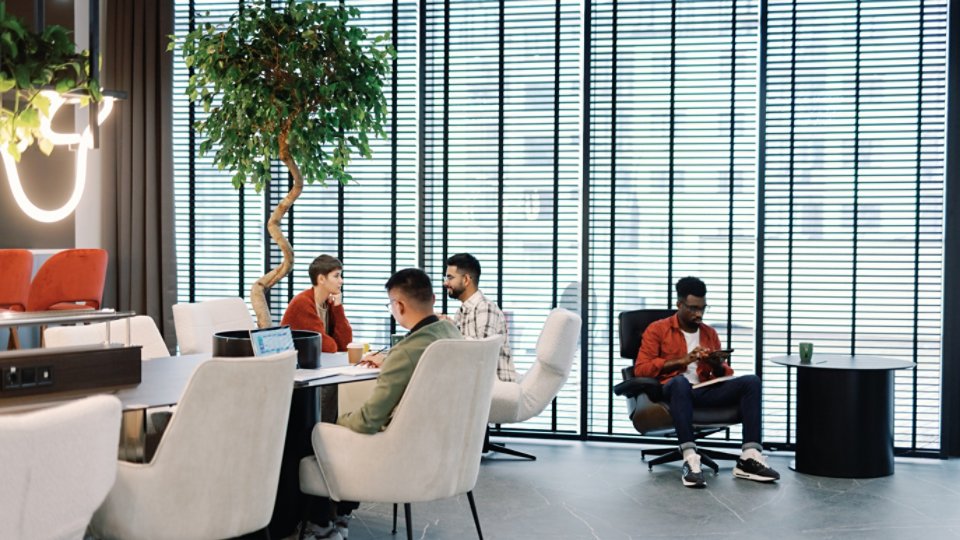 Young multiracial team of IT company working with digital devices in open space office or coworking at daytime. Modern technology and innovation. Business strategy and development. Teamwork concept