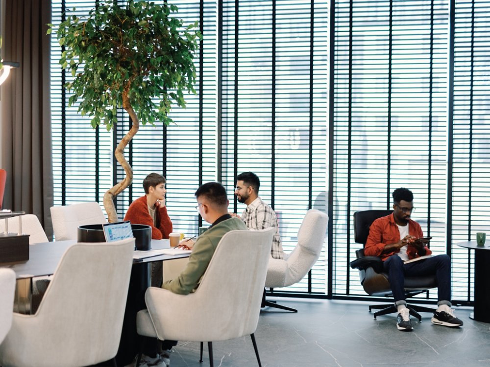 Young multiracial team of IT company working with digital devices in open space office or coworking at daytime. Modern technology and innovation. Business strategy and development. Teamwork concept