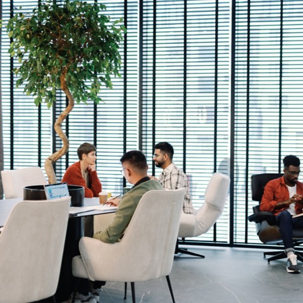 Young multiracial team of IT company working with digital devices in open space office or coworking at daytime. Modern technology and innovation. Business strategy and development. Teamwork concept