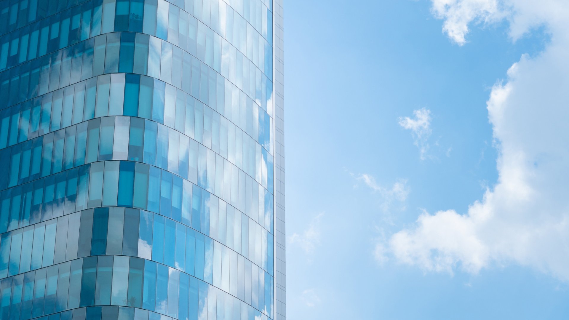 Glass wall architecture building reflection cloud and blue sky background.concept for modern office