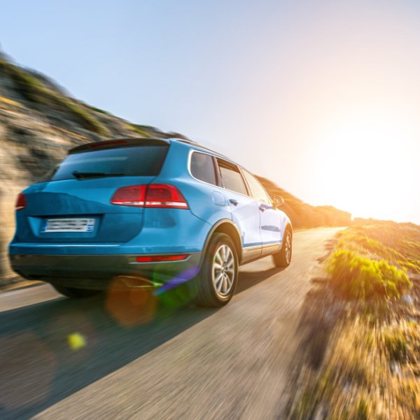 rental SUV car in spain mountain landscape road at sunset