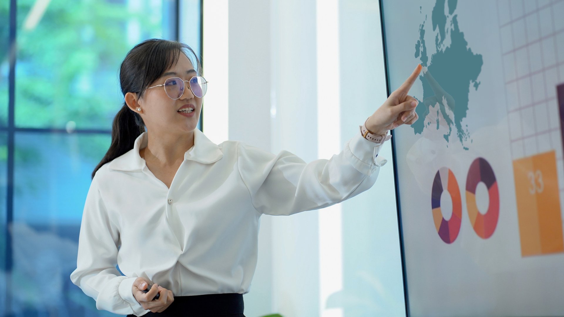 woman pointing at conference room screen
