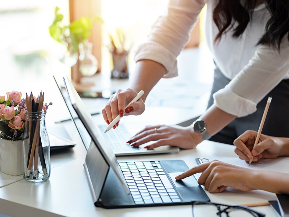 Woman pointing with pen at laptop screen