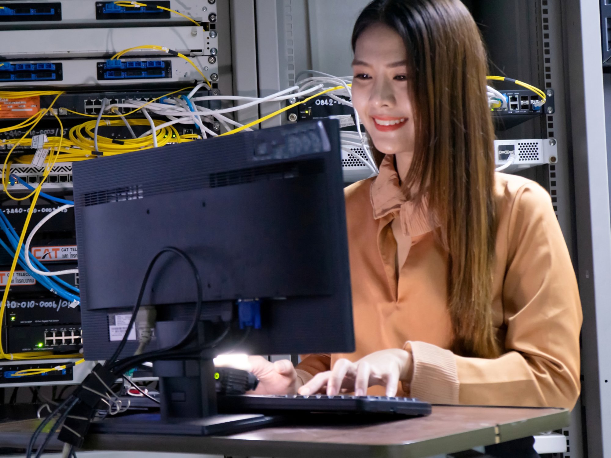 Young female engineer using a Computer working in a server room