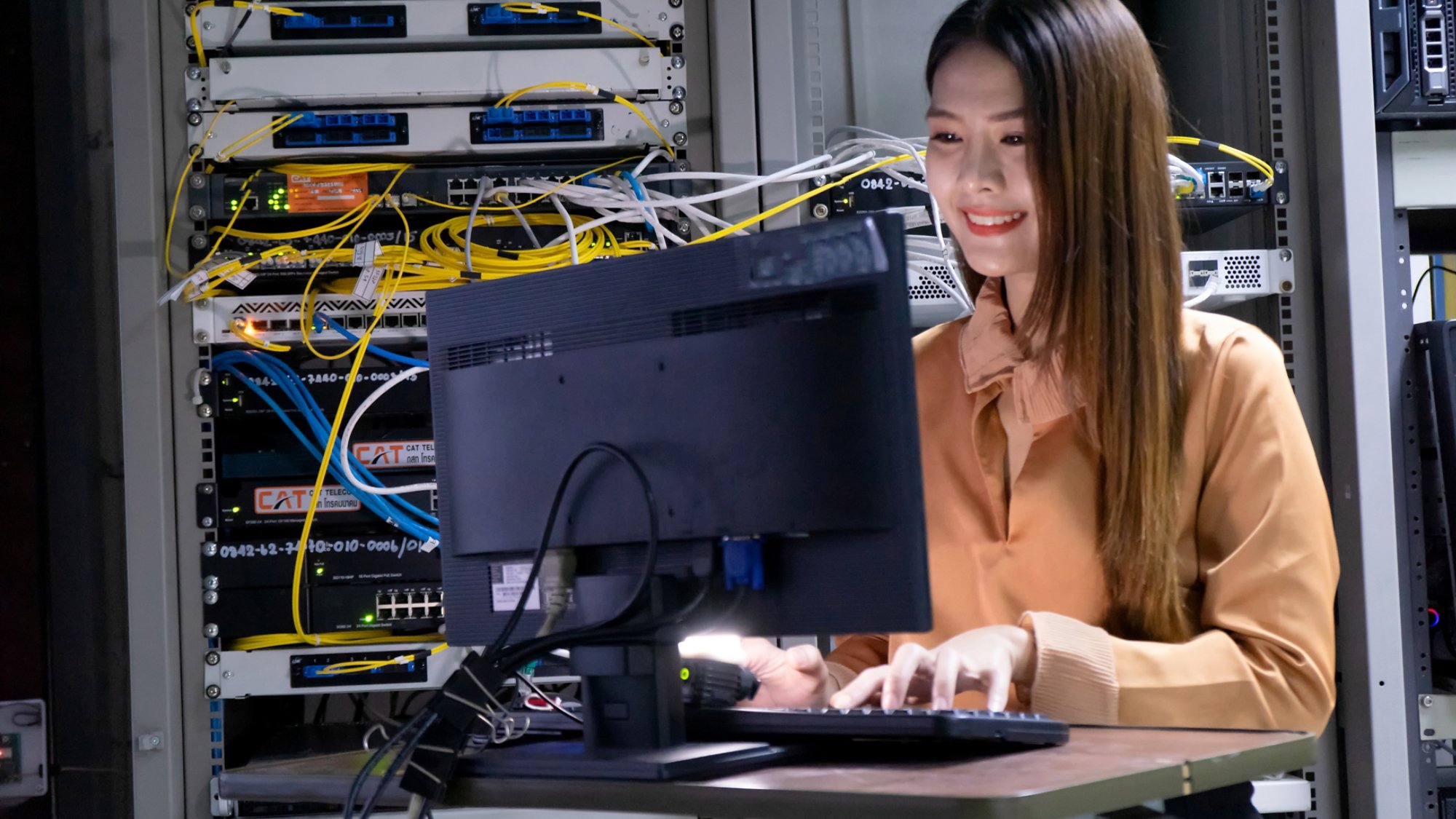 Young female engineer using a Computer working in a server room