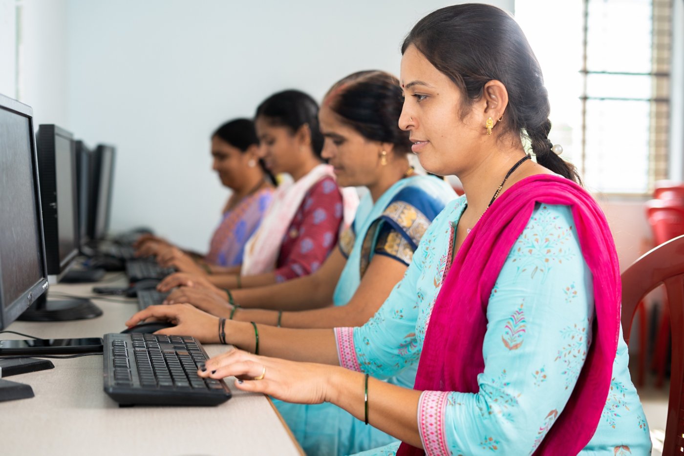 group of women busy learning or working on computer at training center - concept of empowerment, learning and education.