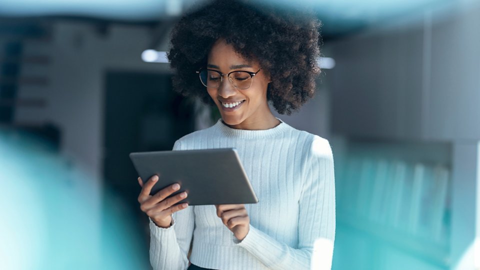 Smiling businesswoman using tablet PC at office