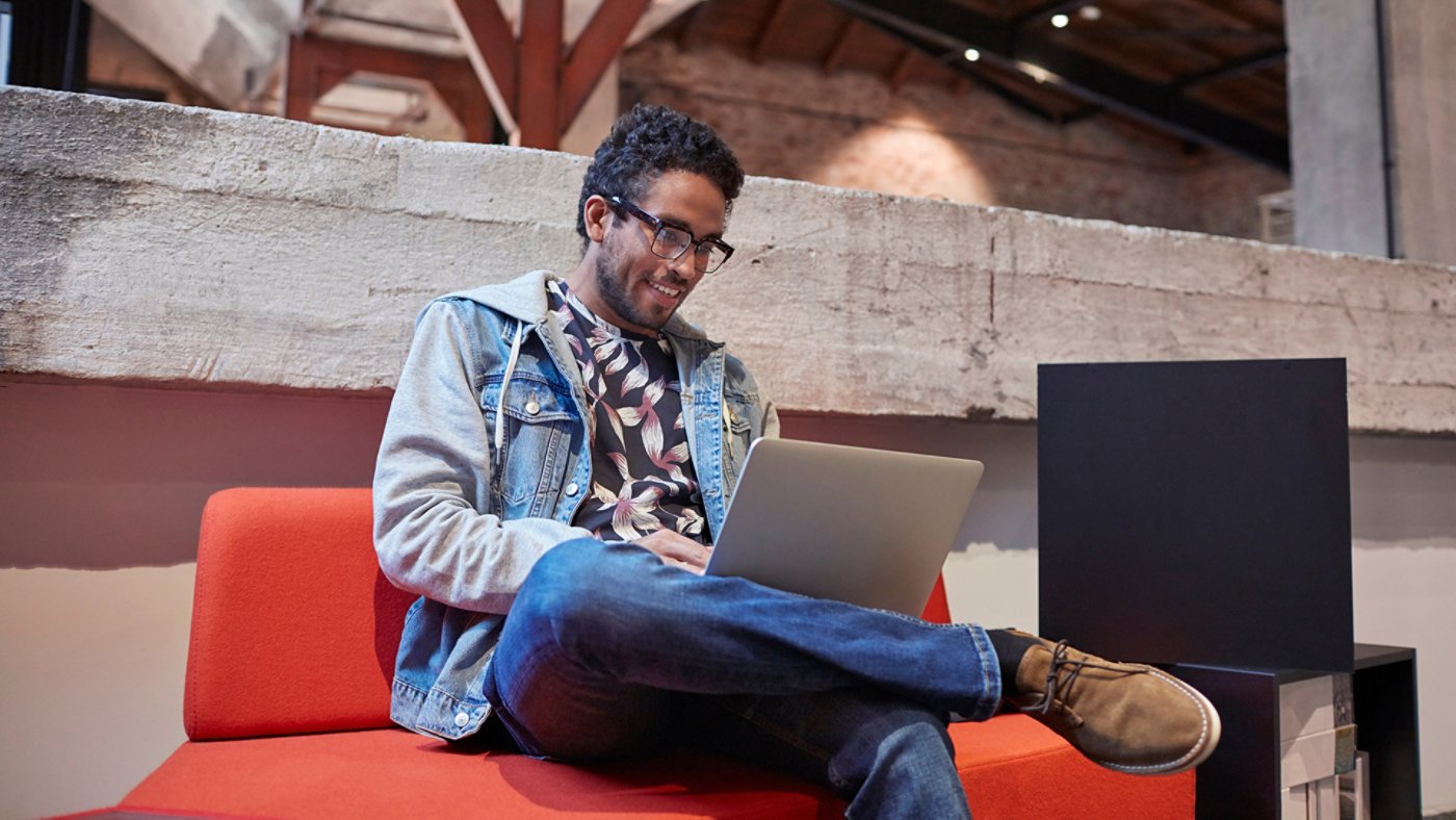 Young man working in creative start-up company, using laptop