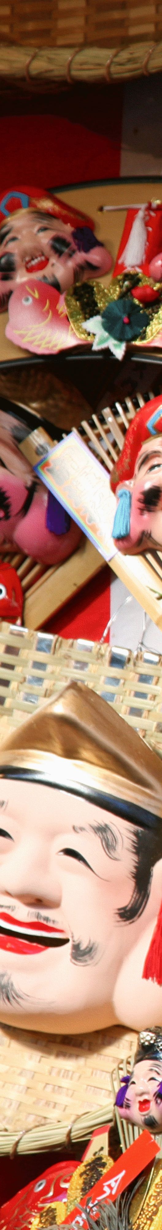 Collection of Japanese masks that depict smiling faces and are mounted on straw baskets