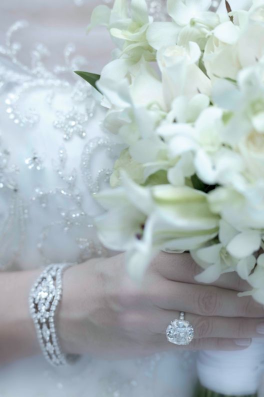 Women in wedding gown holding bouquet of flowers. 