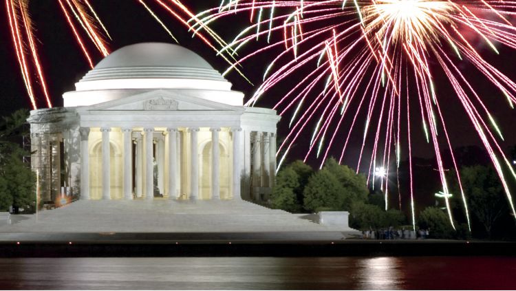 Fireworks explode above a domed building with columns