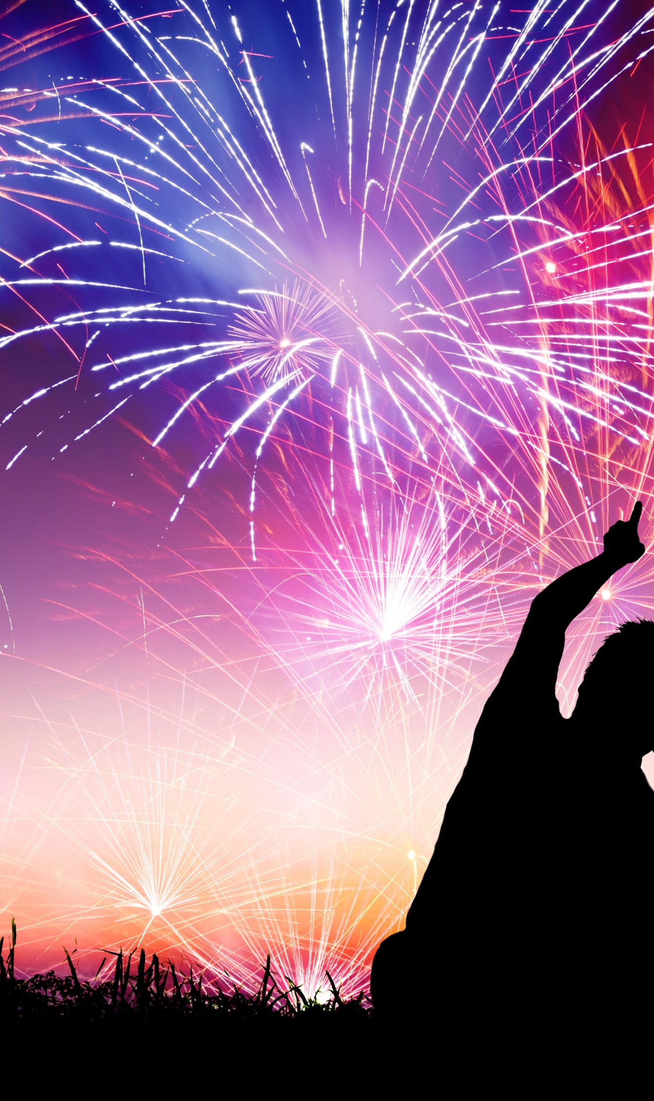 Two people look up at a sky of fireworks