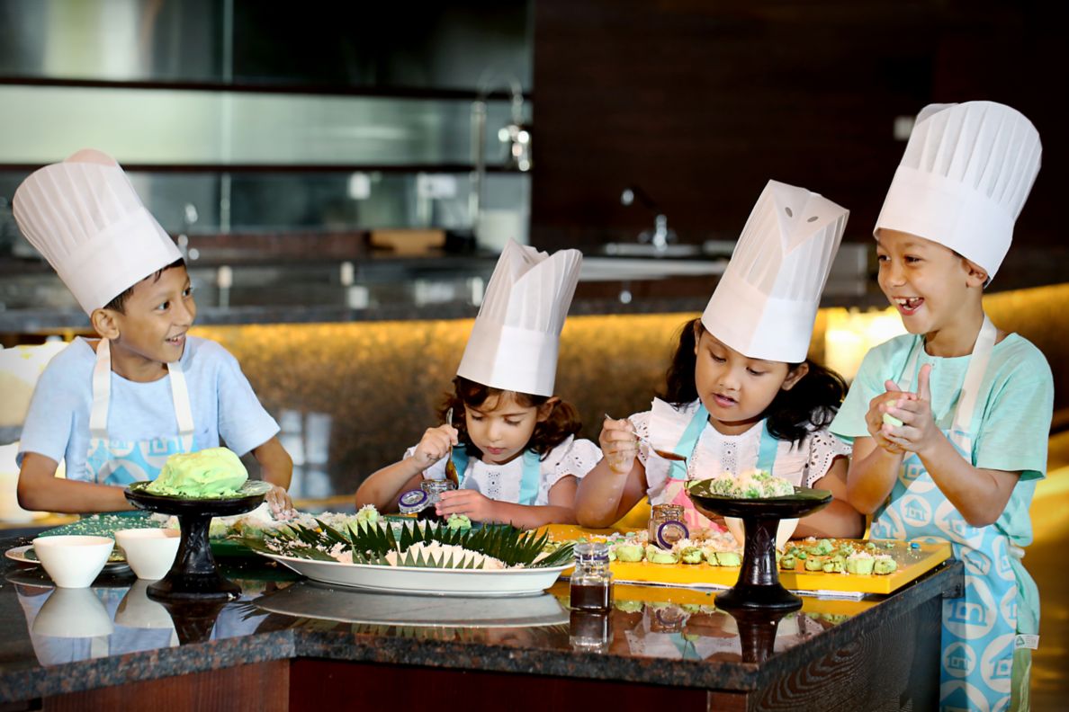 Kids in chef hats during a cooking class.