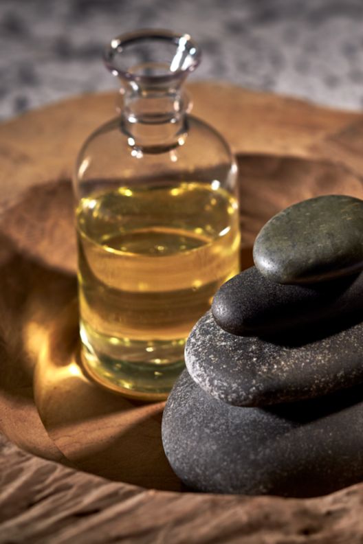 A decorative display of stones and spa oil.