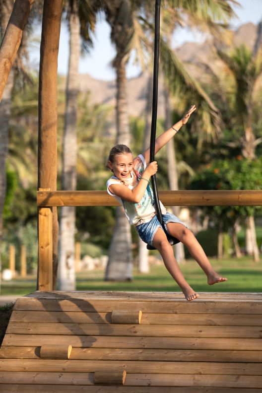 A young girl on a rope swing.
