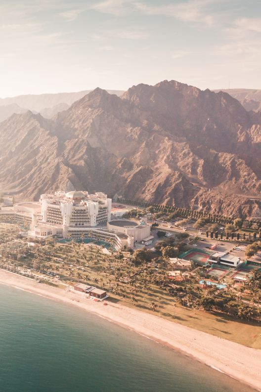 Sun saturated, aerial view of the sea, mountains, hotel grounds and surrounding landscape.