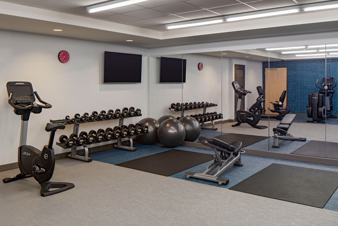 hotel gym with free weights and workout equipment