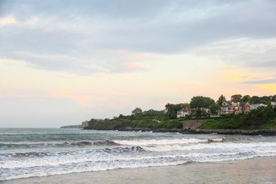 Beach with cliff with houses on it.