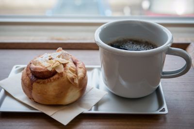 A mug of coffee and a pastry on a table