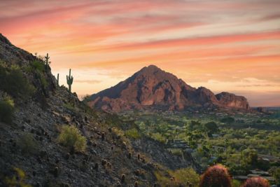 The sun sets over Camelback Mountain and a hiking trail