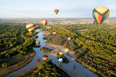 Hot air balloons fly over a field