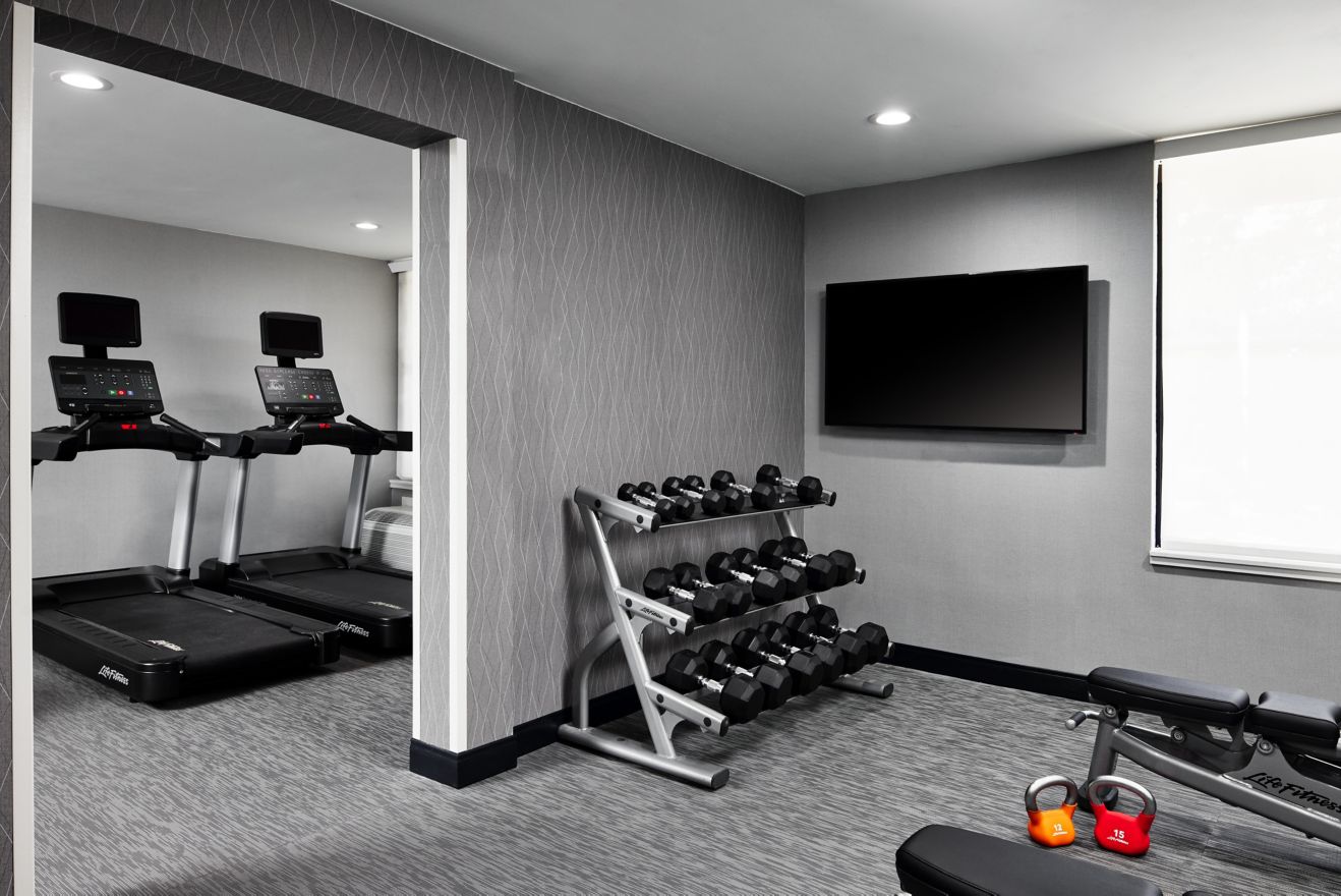fitness center with treadmills, weights and TV