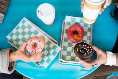 Two people eating donuts at the table
