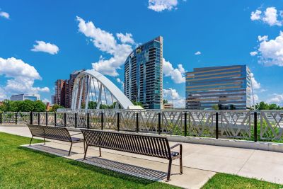 A line of benches outlooking a sculpture and buildings