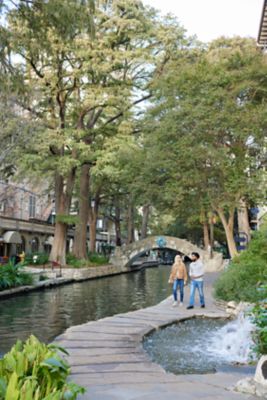 Man and woman stroll through the San Antonio River Walk
