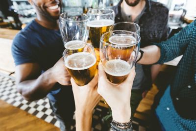 Friends toasting with beer in a pub