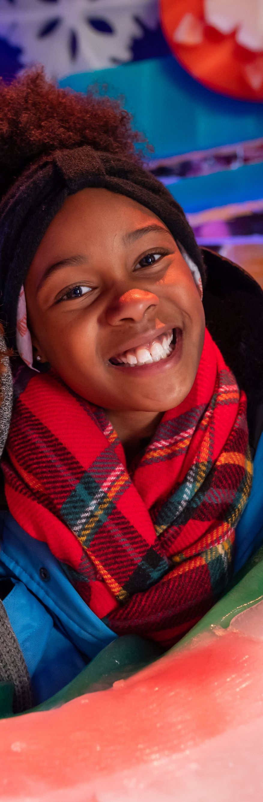 Smiling children looking through an ice carving.