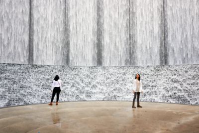 Two people standing at a manmade waterfall