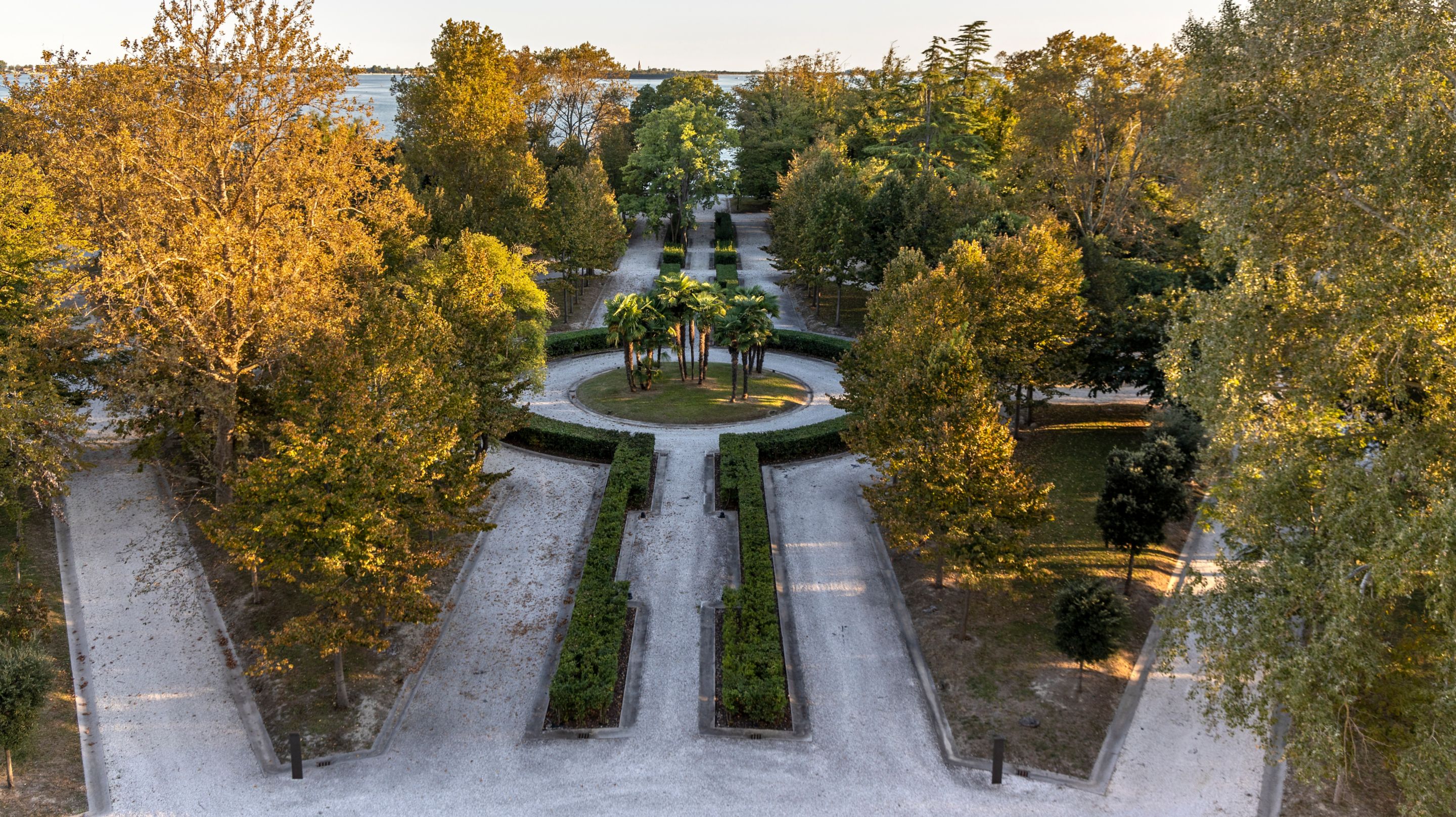 Birds eye view of garden with paths lined with trees.
