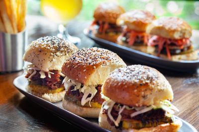 Three small burgers on a plate.